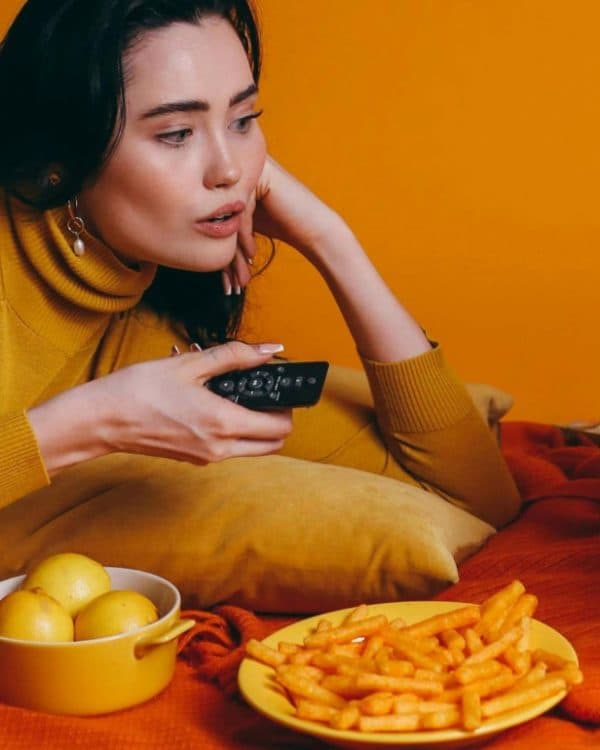 woman eating food while watching TV