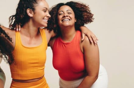 3 women in sportswear embracing each other and smiling